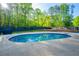 Inviting in-ground pool surrounded by a spacious concrete patio and a lush green backyard at 295 Hollyberry Dr, Roswell, GA 30076