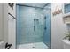 Blue tiled shower boasts a sleek design with glass door, rainfall shower head and built-in niche at 295 Hollyberry Dr, Roswell, GA 30076