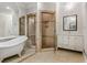 This bathroom features an elegant soaking tub and glass walk-in shower with double mirrors and white cabinets at 3188 Paces Mill Se Rd, Atlanta, GA 30339