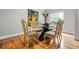 A formal dining room is showcased with a glass table and seating for six with hardwood floors at 3188 Paces Mill Se Rd, Atlanta, GA 30339