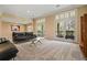 Bright living room with two sliding glass doors, neutral carpet, and modern black leather furniture at 3188 Paces Mill Se Rd, Atlanta, GA 30339