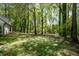 A lush lawn is surrounded by towering trees, creating a beautiful, serene backyard at 1061 Retner Dr, Mableton, GA 30126