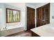 Bathroom with wooden accents, white fixtures, and a window overlooking the outdoors at 1061 Retner Dr, Mableton, GA 30126
