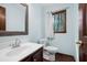 Cozy bathroom with a wooden vanity and a window with views of the trees at 1061 Retner Dr, Mableton, GA 30126