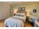 Bright bedroom with hardwood floors, a white-covered bed, accent pillows, and a neutral-colored wall at 145 15Th Ne St # 1015, Atlanta, GA 30309