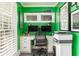 Contemporary green home office with built-in cabinets, dual monitors, and natural light at 3038 Nancy Creek Nw Rd, Atlanta, GA 30327