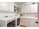 Organized laundry room with modern washer and dryer, cabinets, and ample counter space at 3038 Nancy Creek Nw Rd, Atlanta, GA 30327