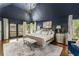 Bedroom with a large bed, elegant furniture, vaulted ceiling, and a dark accent wall at 3038 Nancy Creek Nw Rd, Atlanta, GA 30327