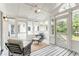 Relaxing screened-in porch with white trim, ceiling fan, and comfortable seating arrangement at 3038 Nancy Creek Nw Rd, Atlanta, GA 30327