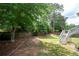 Well-maintained backyard with a manicured lawn, mature trees, landscaped beds, and a wood privacy fence at 4955 Kingsbridge Ct, Powder Springs, GA 30127