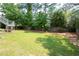 Spacious, manicured backyard features a healthy green lawn, landscaped beds, and a wood privacy fence at 4955 Kingsbridge Ct, Powder Springs, GA 30127