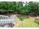Landscaped backyard featuring a grassy lawn, mulched beds, and a wood privacy fence, accessible by a staircase at 4955 Kingsbridge Ct, Powder Springs, GA 30127