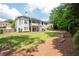 Expansive backyard featuring a well-manicured lawn, mature trees, and a view of the home's exterior at 4955 Kingsbridge Ct, Powder Springs, GA 30127