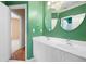 Bathroom showcasing double sinks, modern fixtures, and a view of a hallway with hardwood floors at 4955 Kingsbridge Ct, Powder Springs, GA 30127