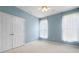 Well-lit bedroom with a double-door closet, carpeted floor, and neutral-toned walls at 4955 Kingsbridge Ct, Powder Springs, GA 30127