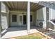 Covered patio with gray siding, a sliding glass door, and concrete flooring, offering a serene outdoor space at 4955 Kingsbridge Ct, Powder Springs, GA 30127