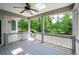 A covered porch features gray trim, a ceiling fan, and white lattice railing overlooking a lush green landscape at 4955 Kingsbridge Ct, Powder Springs, GA 30127
