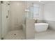 Modern bathroom features a glass-enclosed shower with a built-in bench and a separate soaking tub at 535 Pearl St, Cumming, GA 30040