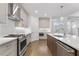 Open kitchen with quartz countertops, stainless steel appliances, and large island with bar seating at 535 Pearl St, Cumming, GA 30040