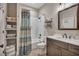 Bathroom featuring a vanity with white countertop, a framed mirror, and a shower with a blue patterned curtain at 803 Willow Oak Dr, Woodstock, GA 30189