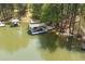 Waterfront property featuring a private covered boat dock with boat, offering easy access to lake activities at 803 Willow Oak Dr, Woodstock, GA 30189