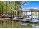 Covered boat dock equipped with boat and seating, perfect for relaxing by the water and enjoying lake views at 803 Willow Oak Dr, Woodstock, GA 30189