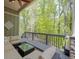 Well-designed deck area with comfortable outdoor seating and view of the surrounding trees at 803 Willow Oak Dr, Woodstock, GA 30189