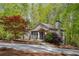 Charming home featuring a stone chimney and a landscaped front yard with mature trees at 803 Willow Oak Dr, Woodstock, GA 30189