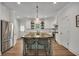Kitchen with a large island, barstool seating, stainless steel refrigerator, and white cabinets at 803 Willow Oak Dr, Woodstock, GA 30189