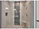 Stylish shower with gray and white tile, built-in niche, and seamless glass door at 803 Willow Oak Dr, Woodstock, GA 30189