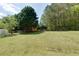 View of the expansive, grass-covered backyard with mature trees and chain link fence surrounding the property at 101 Javay Ct Ct, Villa Rica, GA 30180