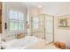 Bright bathroom featuring a soaking tub, a glass-enclosed shower, and a sunlit window at 1015 Heatherbrooke Ln, Atlanta, GA 30324