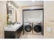 Modern bathroom includes a vanity and sink as well as a front-loading washer and dryer at 3475 Oak Valley Ne Rd # 1720, Atlanta, GA 30326