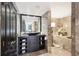 Elegant bathroom featuring a black vanity, marble tiling, and a luxurious soaking tub at 3475 Oak Valley Ne Rd # 1720, Atlanta, GA 30326