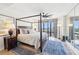 Stunning main bedroom features a four-poster bed, city views from floor-to-ceiling windows, and an elegant blue rug at 3475 Oak Valley Ne Rd # 1720, Atlanta, GA 30326