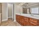 Bathroom with double sinks and vanity with wood cabinets, stand up shower, and tile flooring at 3810 Baverton Dr, Suwanee, GA 30024