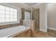 Bright bathroom featuring a soaking tub, a separate tiled shower, and tile flooring at 3810 Baverton Dr, Suwanee, GA 30024