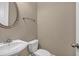 Neutral powder room featuring a pedestal sink, white toilet, and a modern round mirror at 3810 Baverton Dr, Suwanee, GA 30024