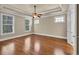Bedroom with tray ceiling, ceiling fan, hardwood floors, and three windows at 3810 Baverton Dr, Suwanee, GA 30024