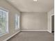 Bedroom with neutral walls, tan carpeting and large windows allowing for lots of natural light at 3810 Baverton Dr, Suwanee, GA 30024