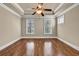 Empty bedroom features tray ceilings, wood floors, ceiling fan, and natural light from windows at 3810 Baverton Dr, Suwanee, GA 30024