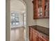 Elegant butler pantry with wood cabinets, granite counters, and arched doorway at 3810 Baverton Dr, Suwanee, GA 30024