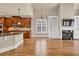 Open-concept living room and kitchen with wooden cabinets, island, stainless appliances, and hardwood flooring at 3810 Baverton Dr, Suwanee, GA 30024