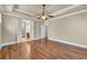 Primary bedroom featuring tray ceilings, ceiling fan, hardwood floors and access to bathroom at 3810 Baverton Dr, Suwanee, GA 30024