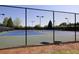 Community tennis courts behind a black fence under the bright sky at 3810 Baverton Dr, Suwanee, GA 30024