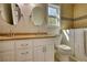 Bright bathroom with double vanity, round mirrors, tiled accent wall, walk-in bathtub and natural light at 72 Grayson New Hope Rd, Grayson, GA 30017