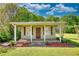Charming outbuilding with a covered porch, brown shutters and door, and lush landscaping at 72 Grayson New Hope Rd, Grayson, GA 30017