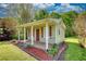Charming outbuilding with a covered porch, brown shutters and door, and lush landscaping at 72 Grayson New Hope Rd, Grayson, GA 30017
