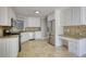 Well-lit kitchen with stainless steel appliances, white cabinets, and tile backsplash at 72 Grayson New Hope Rd, Grayson, GA 30017