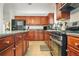 Close up view of a modern kitchen featuring stainless steel appliances, a granite countertop, and wooden cabinets at 205 E Skyline Vw, Dallas, GA 30157
